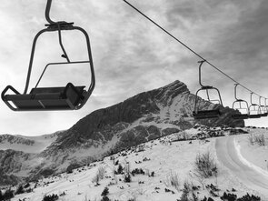 Snow-covered mountains with a chairlift in the foreground.
