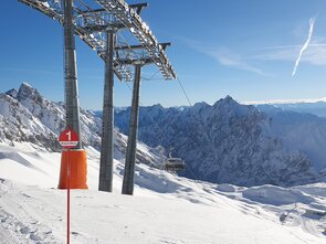 View of snow-covered mountains and cable car under sunlight.
