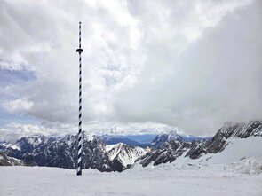 Snow-covered alpine landscape with a viewpoint.