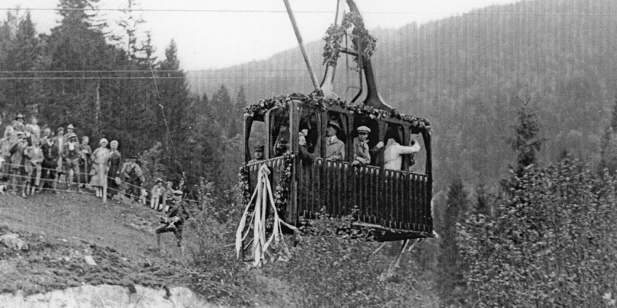 Historical image of a cable car opening with spectators.