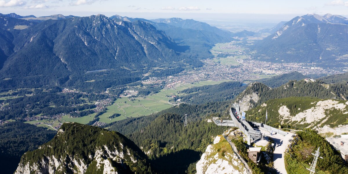 Panoramablick auf die Alpenlandschaft mit grünen Tälern.