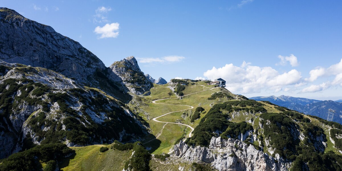 Mountain landscape with winding road and blue sky.