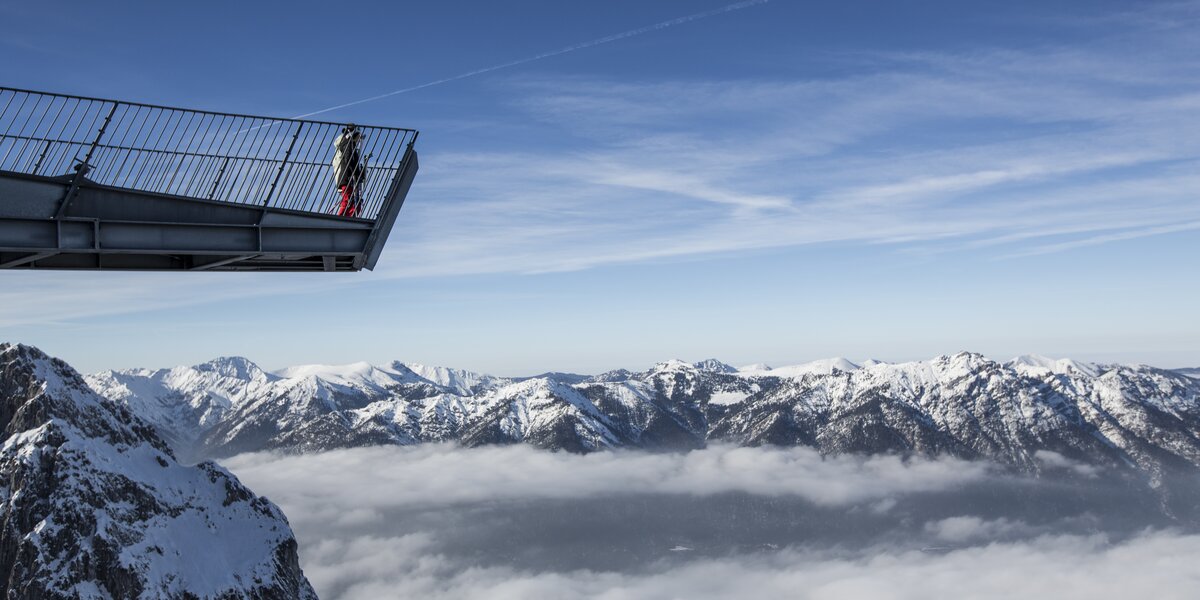 Ausschichtsplattform AlpspiX mit Blick über das Nebelmeer im Tal und schneebedeckte Berge.