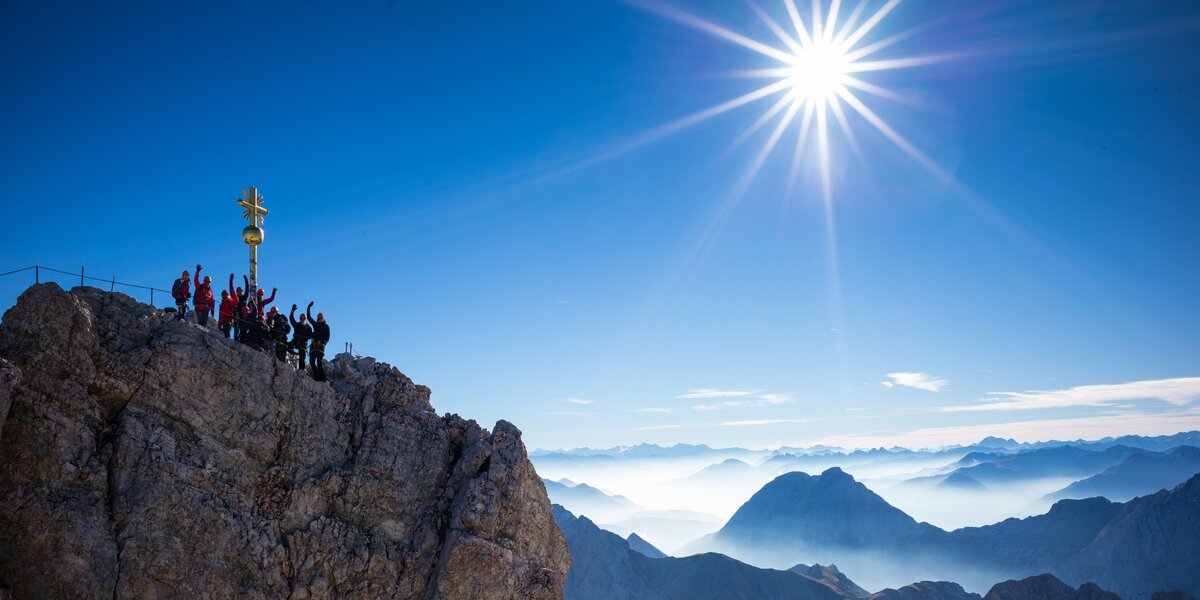 Group of climbers on a summit enjoying the sunshine.