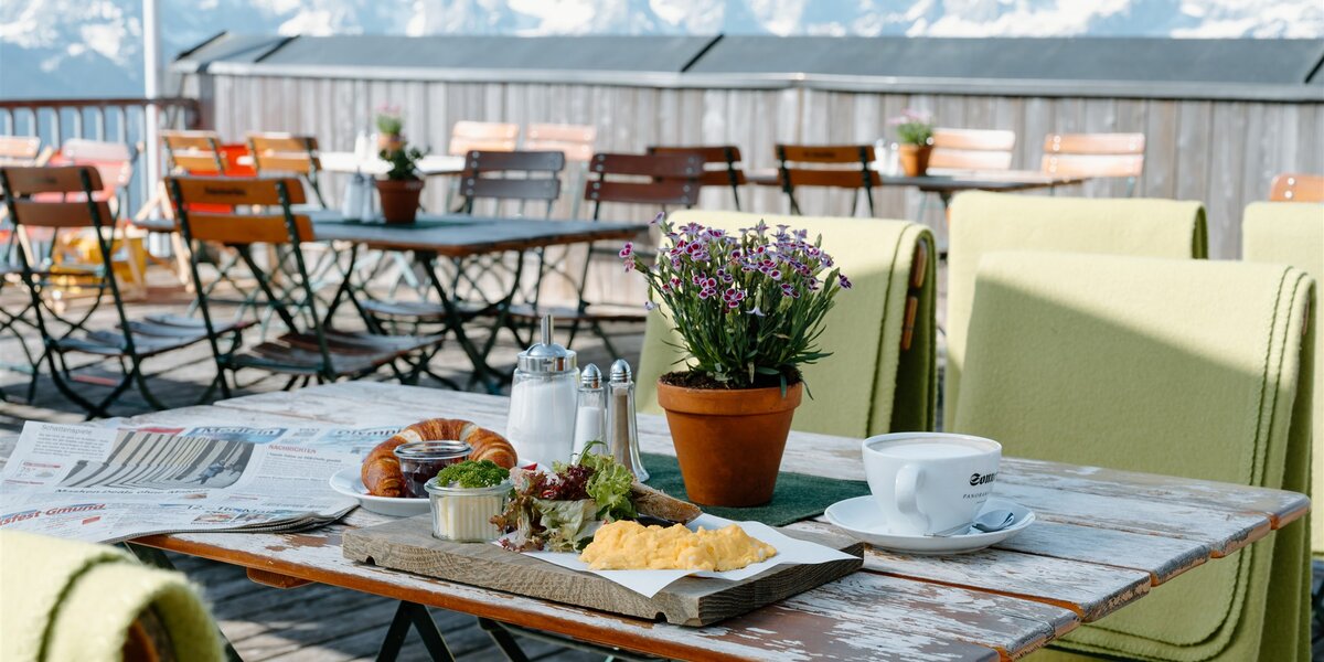 Genießen Sie ein köstliches Frühstück im Freien mit Panoramablick auf die Berge.