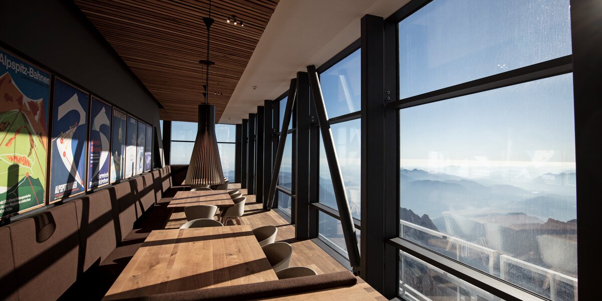 Stylish restaurant with wooden decor and panoramic windows to the mountains.