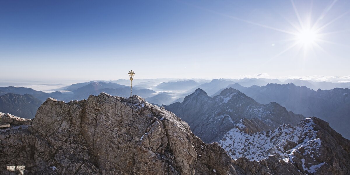 Panorama of snow-covered mountains beneath a bright sunlight.