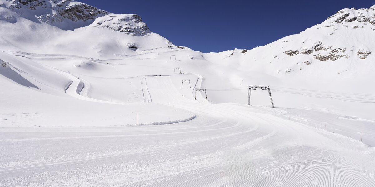 Ein ruhiges Snowboardgebiet mit leeren Pisten und blauen Himmel.